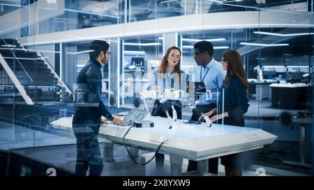 Diverse Multiethnic Team of Industrial Robotics Engineers Gathered Around a Table With a Robot Dog. Scientists Use Laptop Computer to Research, Develop and Program the Four-Legged Robot. Stock Photo