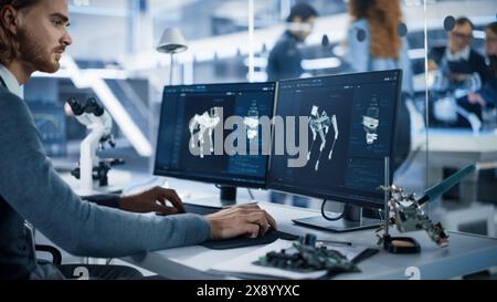 Robotics Engineer Working on Programming a Robot Dog on Desktop Computer. Young Team of International Industrial Science Specialists Developing a Mobile Futuristic Robot in the Background. Stock Photo