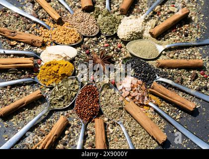 various spices on wooden spoons, with star anise, cinnamon sticks and curry Stock Photo