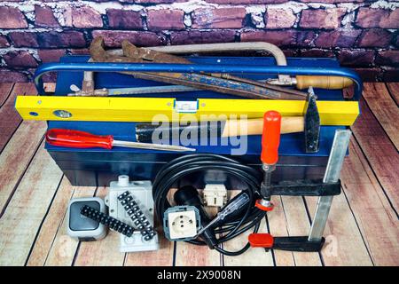 toolbox with switch, socket, light bulb and power cable, symbol image for electricians Stock Photo