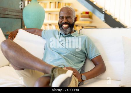 At home, African American senior man wearing light blue polo, smiling broadly Stock Photo