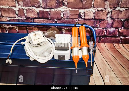 toolbox with switch, socket, light bulb, voltage tester and power cable, symbol image for electricians Stock Photo