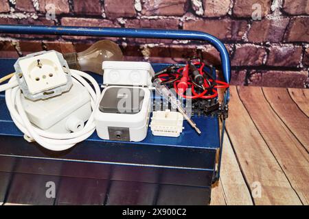 toolbox with switch, socket, light bulb, voltage tester and power cable, symbol image for electricians Stock Photo
