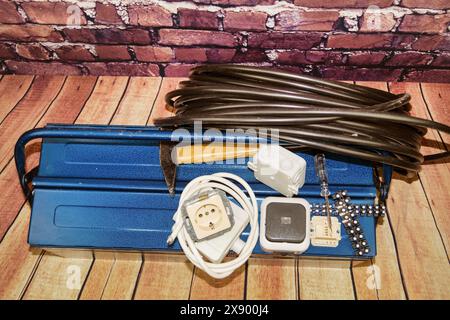 toolbox with switch, socket, light bulb and power cable, symbol image for electricians Stock Photo