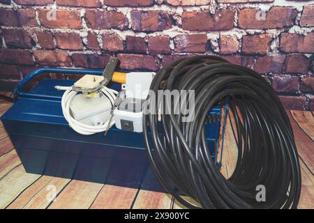 toolbox with switch, socket, light bulb and power cable, symbol image for electricians Stock Photo