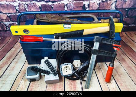 toolbox with switch, socket, light bulb and power cable, symbol image for electricians Stock Photo