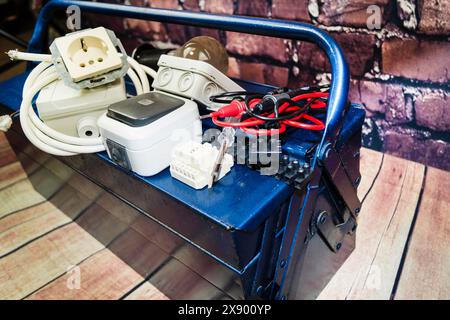 toolbox with switch, socket, light bulb, voltage tester and power cable, symbol image for electricians Stock Photo