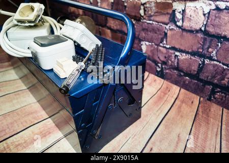 toolbox with switch, socket, light bulb and power cable, symbol image for electricians Stock Photo
