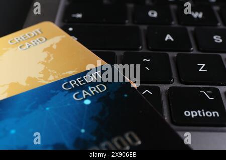 Two plastic credit cards on laptop, closeup Stock Photo