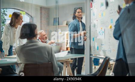 Multiethnic Business Team Discussing Strategy in a Meeting Room at the Office. Latin Male Designer Brainstorming with Heads of Departments and Deciding on a Marketing campaign for New Product Launch Stock Photo