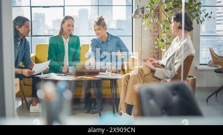 Multi Ethnic Creative Group of People Working on Developing Growth Ideas Based on Data. Energetic Teammates in a Stylish Meeting Room in an Office, Analyzing Charts Using Tablet and Laptop Stock Photo