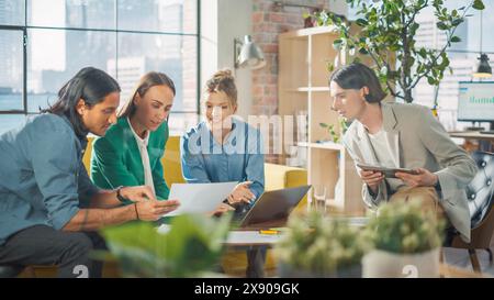 In the Stylish Modern Office Meeting Room: Diverse Group of Business Growth Marketing Professionals Use Laptop and Tablet, Discuss Project Ideas, Brainstorm Company Strategies Stock Photo
