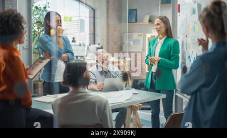 Woman Doing a Presentation in a Meeting Room at Office With her Team. Female Excutive Manager Presenting Company Growth Data and Marketing Strategy. Colleagues Asking Questions, Paying Attention Stock Photo