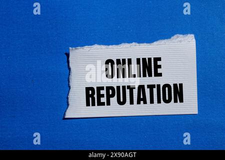 Online reputation words written on ripped white paper piece with blue background. Conceptual online reputation symbol. Copy space. Stock Photo