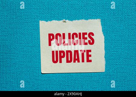 Policies update words written on ripped paper with blue background. Conceptual policies update symbol. Copy space. Stock Photo