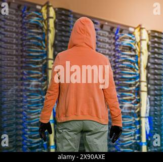 Rearview shot of a male hacker cracking a AI code in a data center of AI. Stock Photo