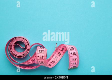 Pink plastic measure tape with metric scale over on blue background. Top view. Diet concept Stock Photo