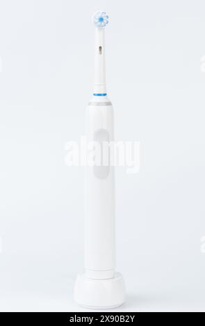 Electirc toothbrush on wireless charger stand isolated on white studio background Stock Photo
