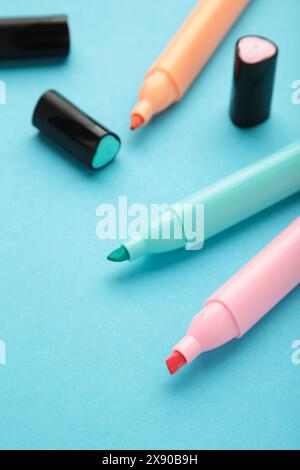 Open markers and space for text on blue background. Pink, blue and orange highlighters Stock Photo