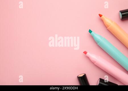 Open markers and space for text on pink background. Pink, blue and orange highlighters Stock Photo