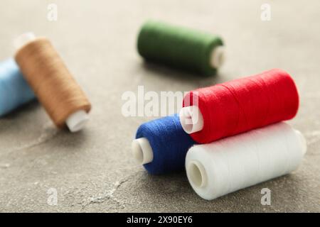 Color sewing threads on grey background, top view Stock Photo