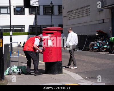 Post office  Postman emptying Royal Mail, postbox in Central London UK Stock Photo