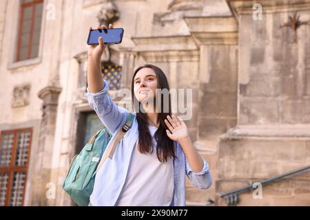 Beautiful travel blogger with smartphone streaming outdoors Stock Photo