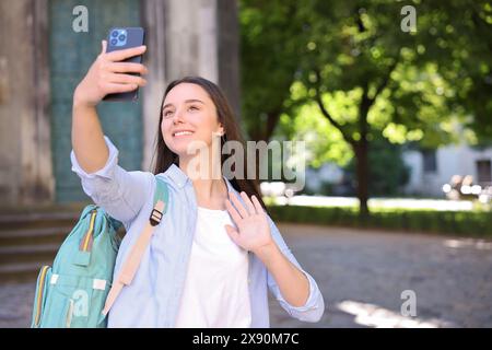 Beautiful travel blogger with smartphone streaming outdoors Stock Photo