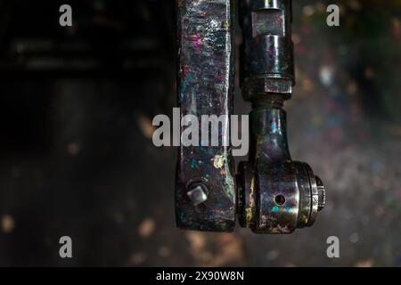 A steel shaft of the historical letterpress machine is seen splattered with printing inks at a printing workshop in Cali, Colombia. Stock Photo