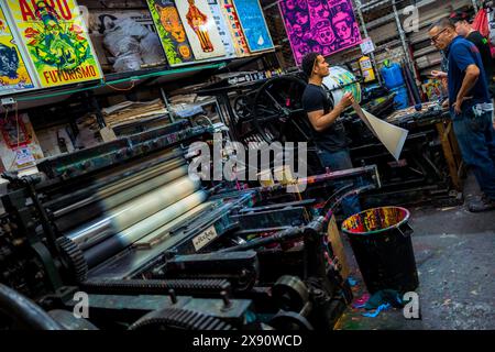 Colombian printers work on the historical letterpress machines at a printing workshop in Cali, Colombia. Stock Photo