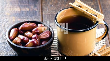 glass of quentão, drink served hot in the Brazilian winter made with lemon, ginger, drip or cachaça and cinnamon sticks. With portion of pine nuts, Br Stock Photo