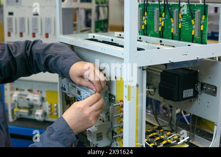 Perm, Russia - May 23, 2024: worker assembling electrical equipment in a factory Stock Photo