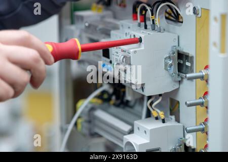 Perm, Russia - May 23, 2024: worker assembling electrical equipment in a factory Stock Photo