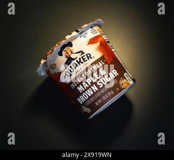Quaker Maple and Brown Sugar instant oatmeal cup on black matte background. Stock Photo