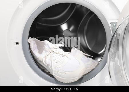 Stylish clean sneakers inside modern washing machine Stock Photo