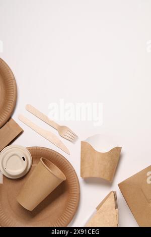 Eco friendly food packaging. Paper containers and tableware on white background, flat lay. Space for text Stock Photo