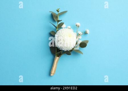 Small stylish boutonniere on light blue background, top view Stock Photo