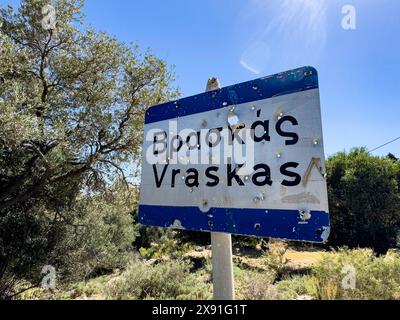 Bullet holes in town sign is target for target practice perforated by bullets, Crete, Greece Stock Photo