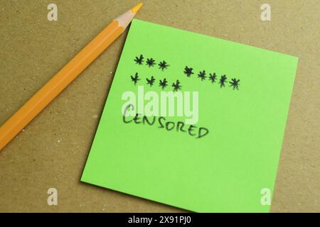 Concept of Censored write on sticky notes isolated on Wooden Table. Stock Photo