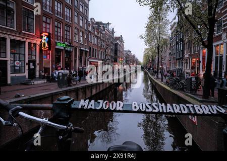 Netherlands, Amsterdam - April 10, 2024: Amsterdam city canals and streets, leading to the famous Red Light district from Majoor Bosshardtbrug Stock Photo