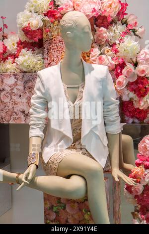 A seated female mannequin in a shop display Stock Photo