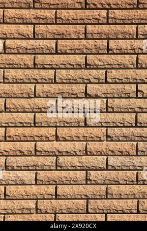 Terracotta, sandy-brown backdrop. Decorative wall texture, background. Cream-colored grungy brick wall in stone style Stock Photo