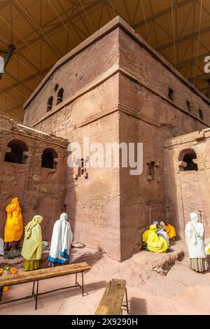 Women pilgrims gathered for mass service at the walls of rock hewn monolithic ortodox church of Bete Maryam, Lalibela, Amhara Region, Ethiopia. Stock Photo