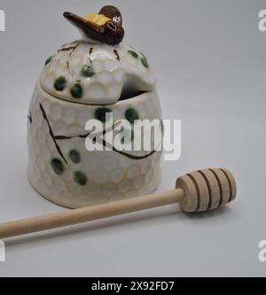Ceramic Beehive Honey Pot and Wooden Dipper on White Background Stock Photo