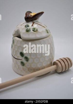 Ceramic Beehive Honey Pot and Wooden Dipper on White Background Stock Photo