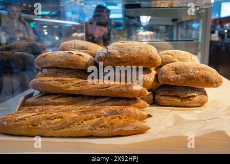 Different kinds of fresh breads, baguettes and ciabatta on display of bakery. Stock Photo
