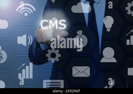 CMS. Man using virtual screen, closeup. Scheme with icons on blue background Stock Photo