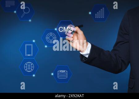 CMS. Man using virtual screen, closeup. Scheme with icons on blue background Stock Photo