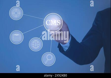 CMS. Man using virtual screen, closeup. Scheme with icons on blue background Stock Photo