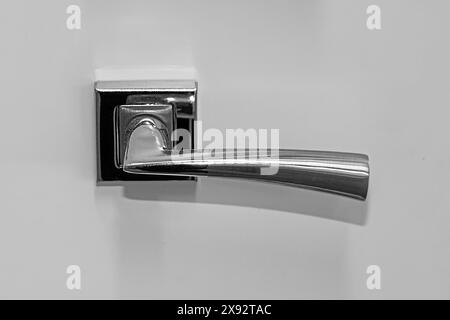 Modern silver door handle on wooden interior door Stock Photo